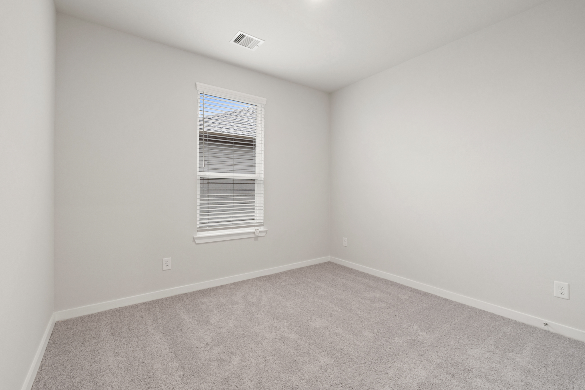 A room with a window and carpet.