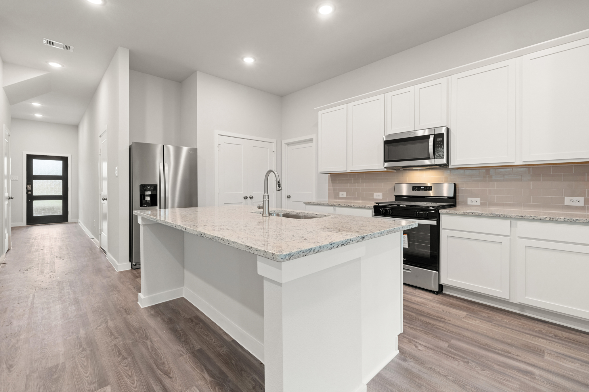 A kitchen with white cabinets.