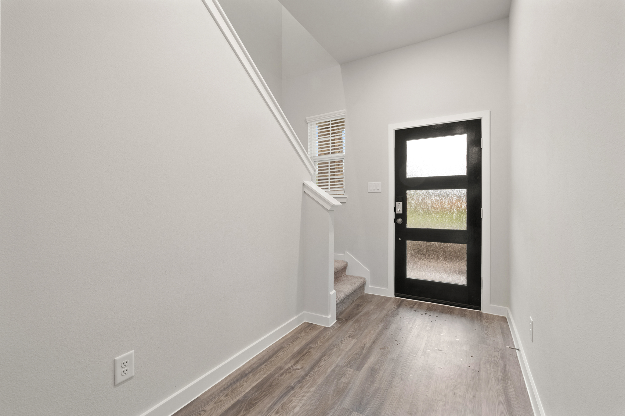 A room with a wood floor and a window.