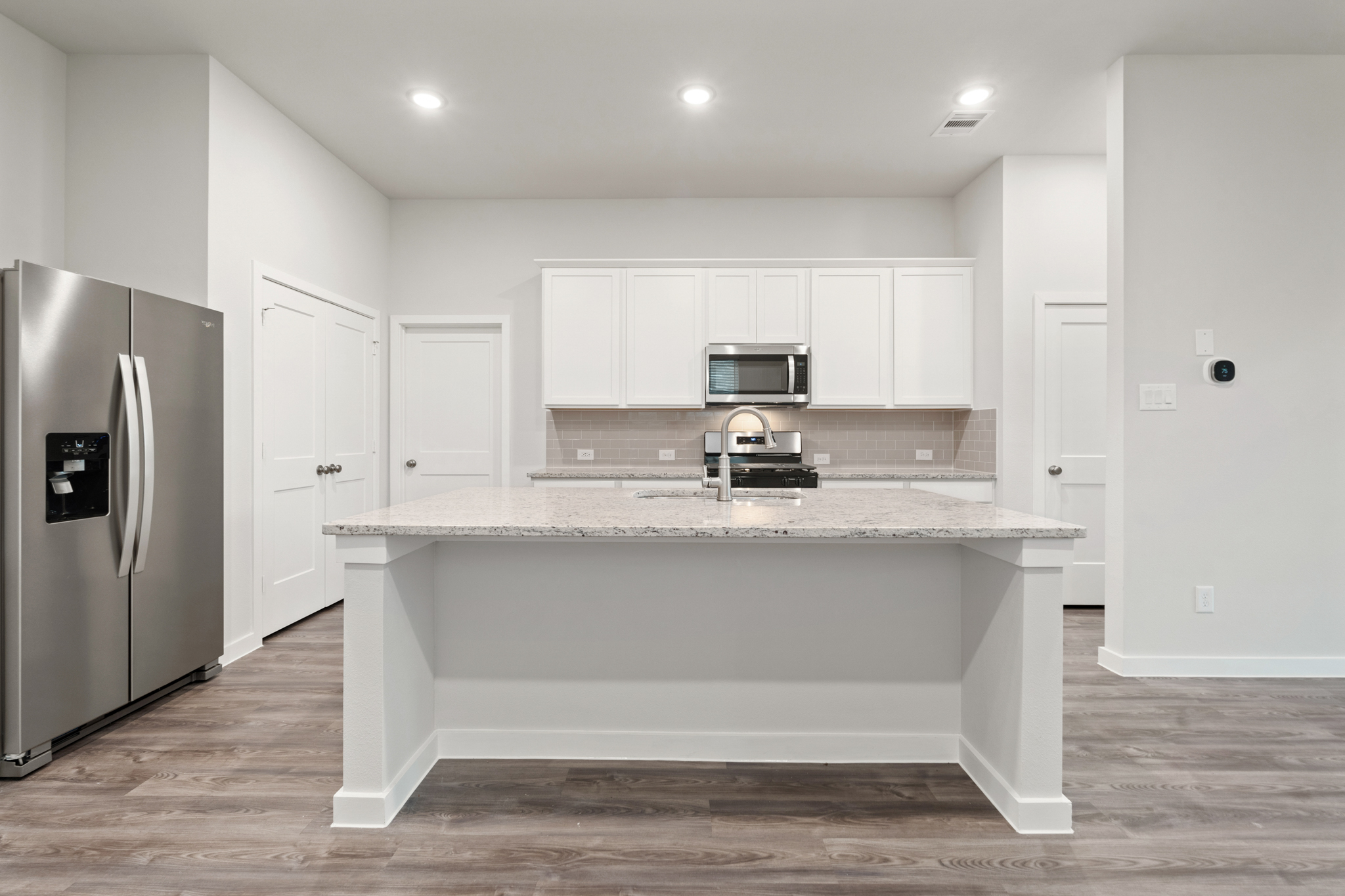 A kitchen with white cabinets.