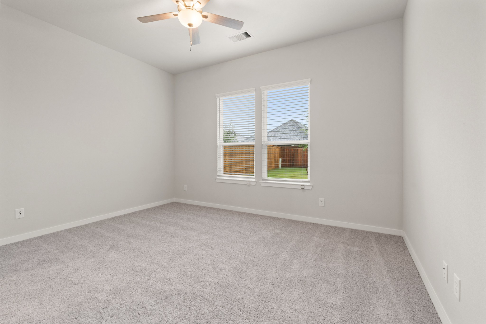 A room with a ceiling fan and a window.