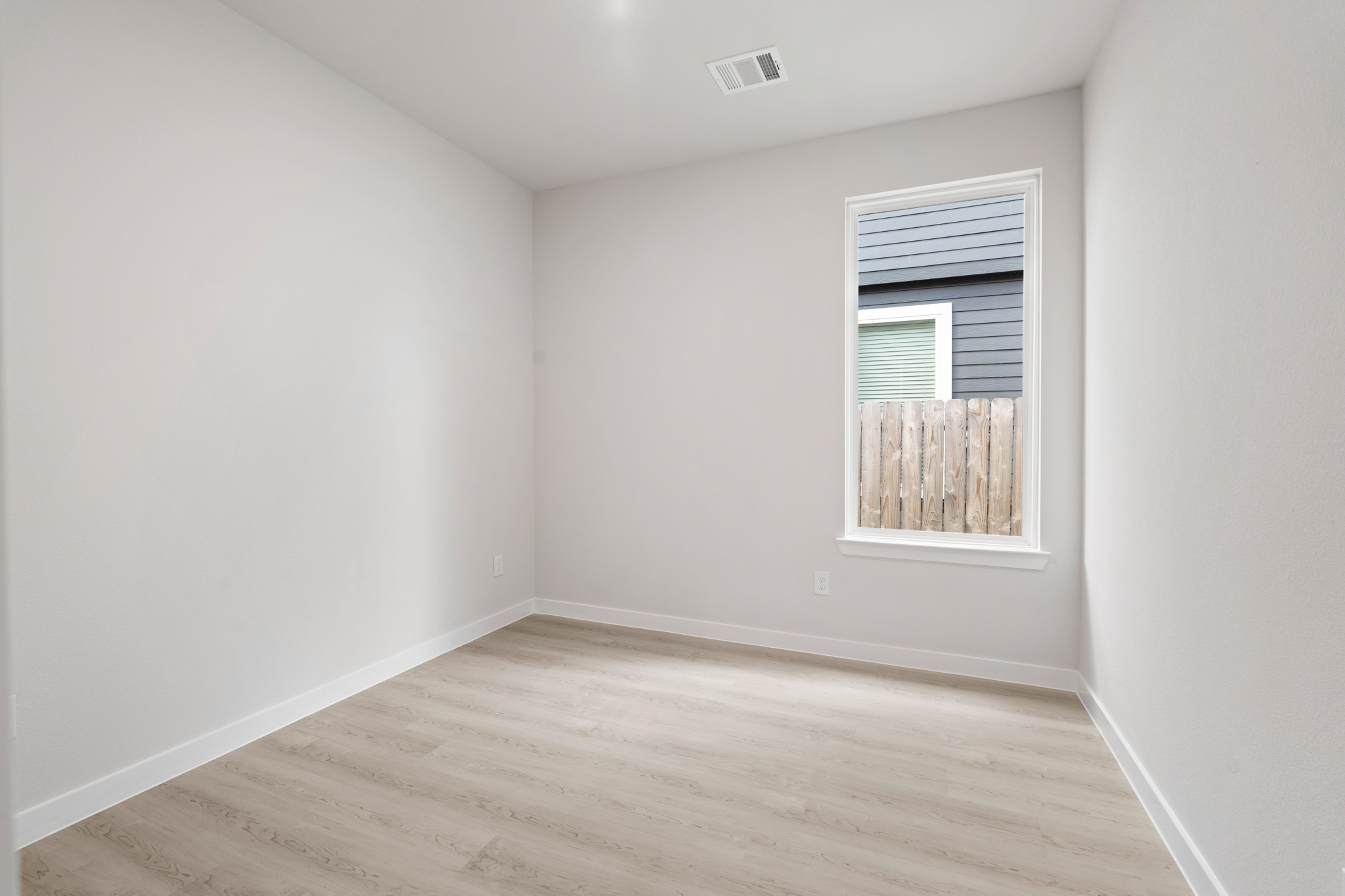 A room with a wood floor and a window.