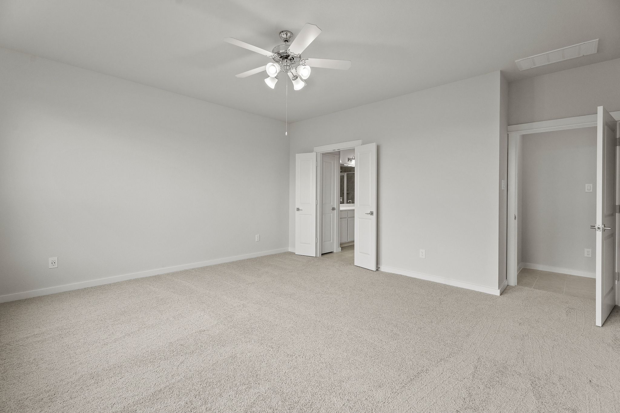 A room with a ceiling fan and a door.