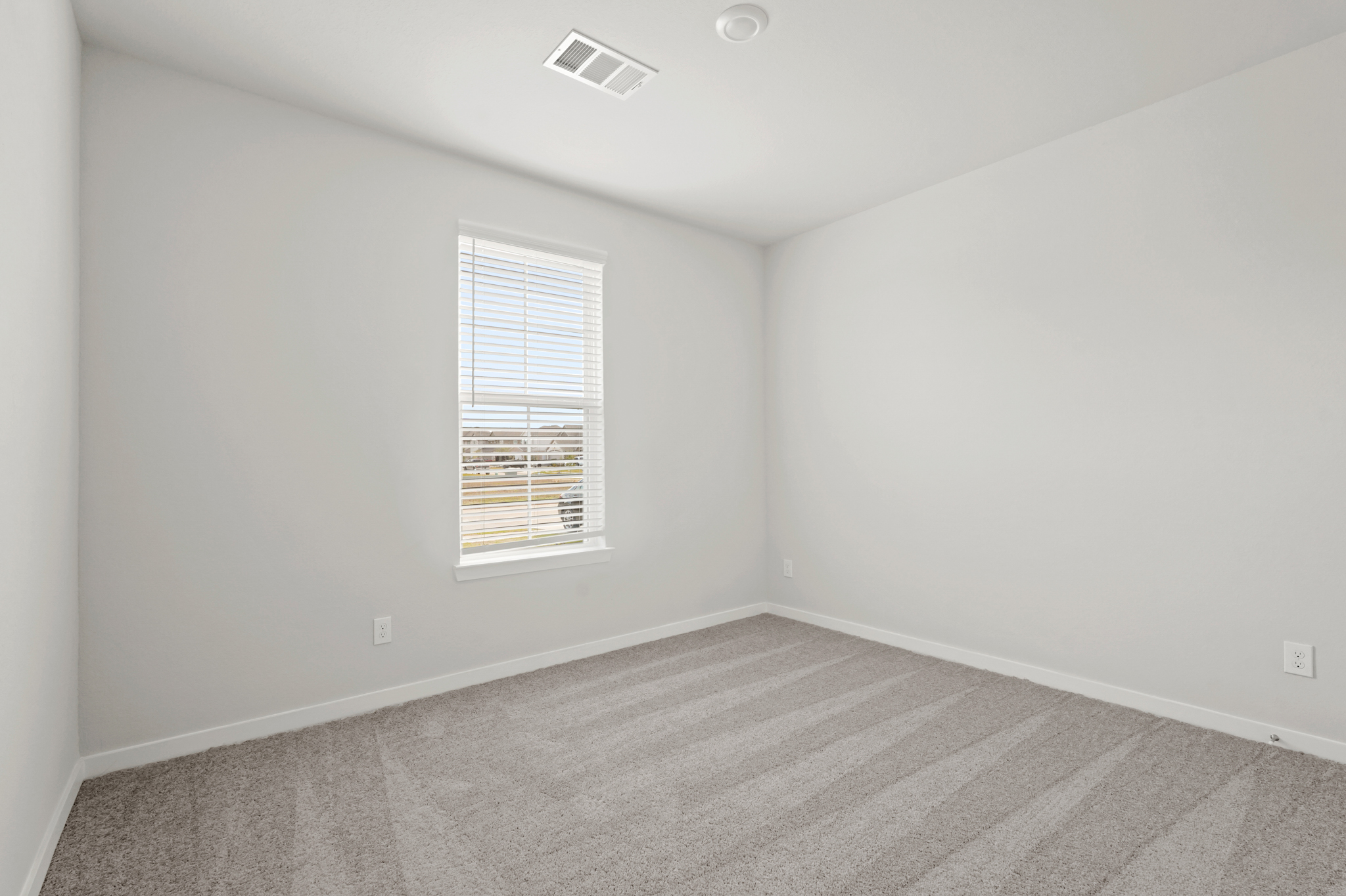A room with a window and a carpet.