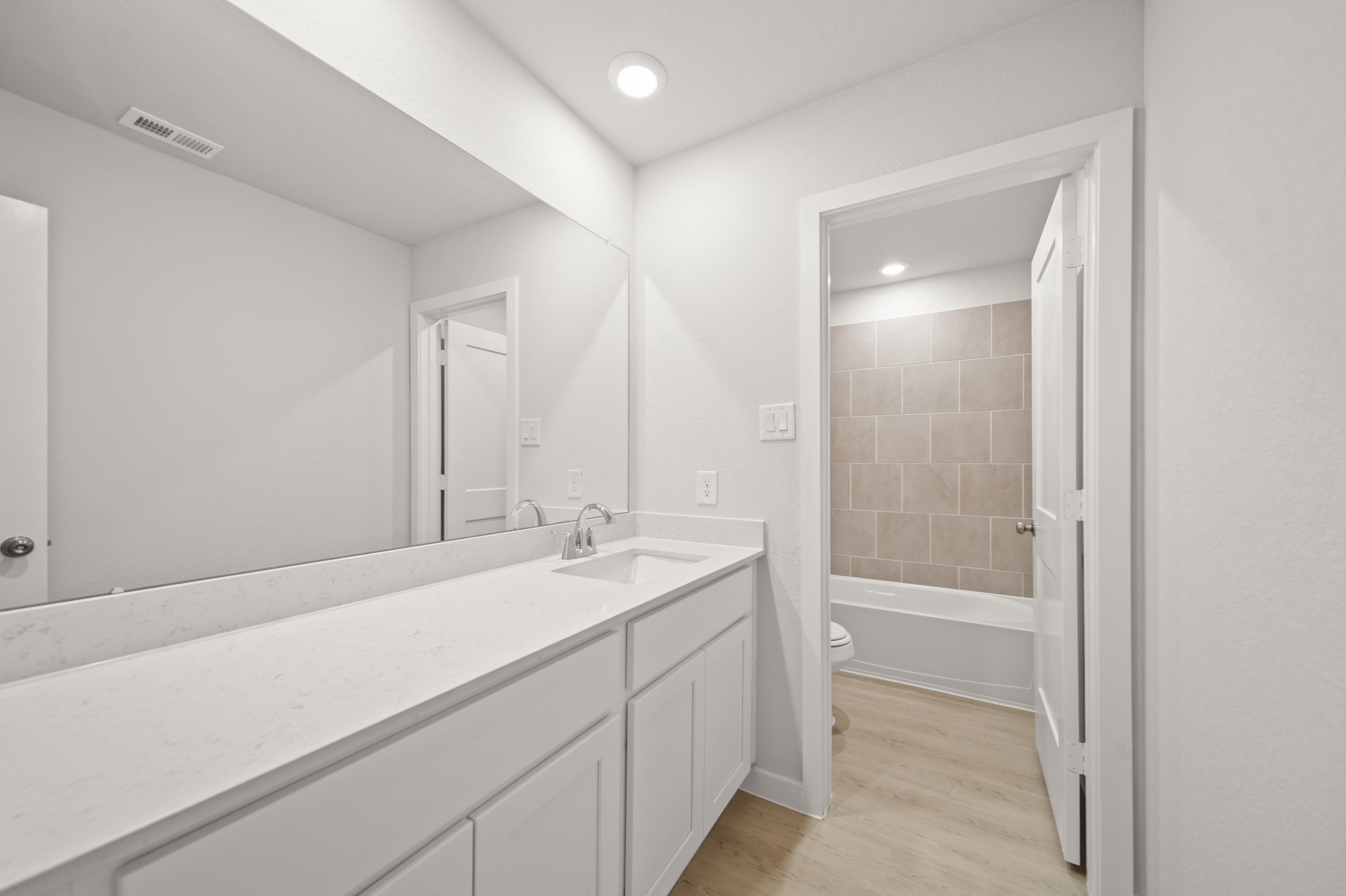 A bathroom with a tub sink and a shower unit.