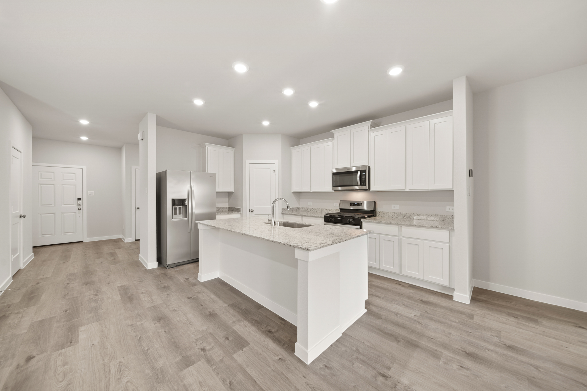 A kitchen with white cabinets.