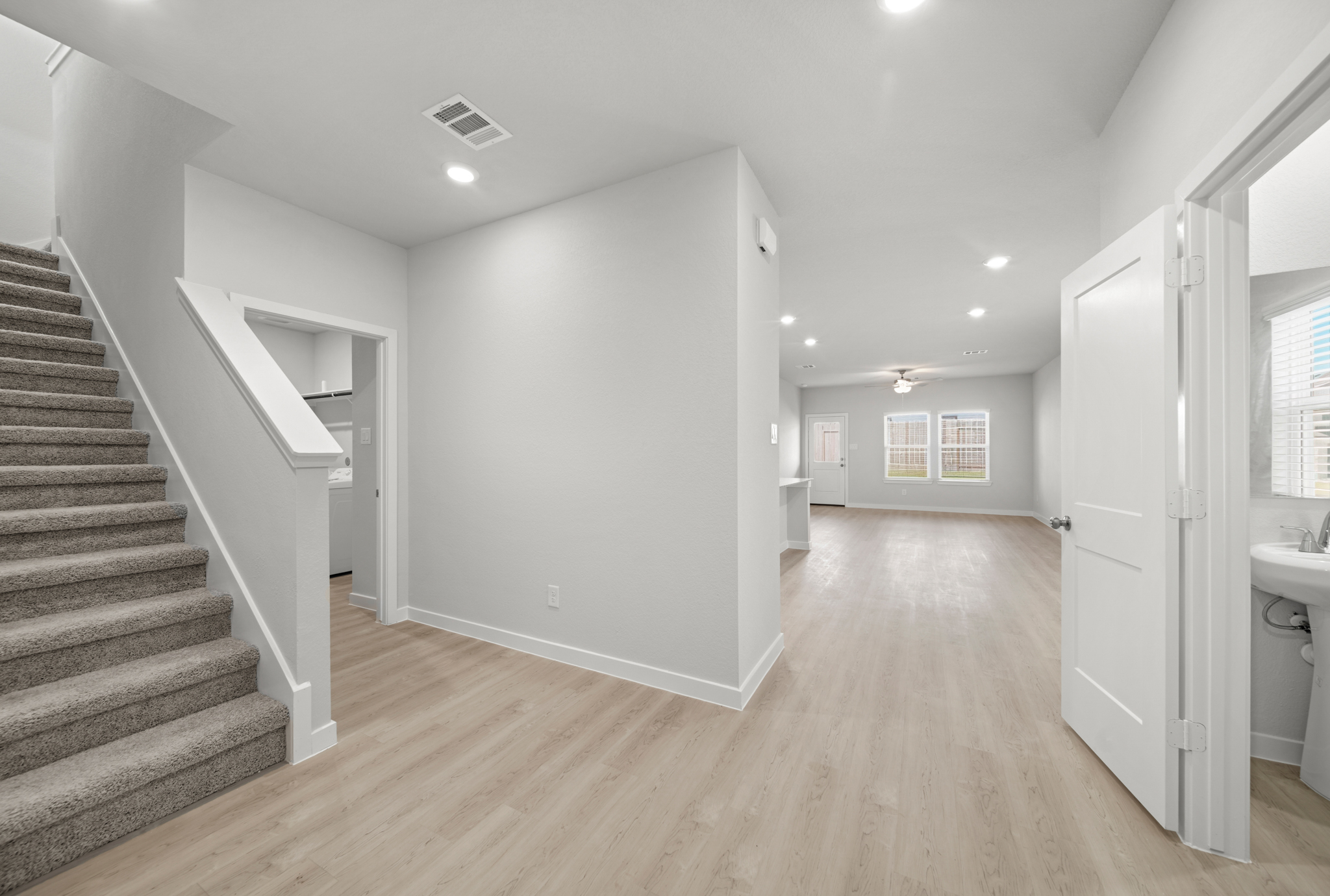 A large empty room with a staircase.