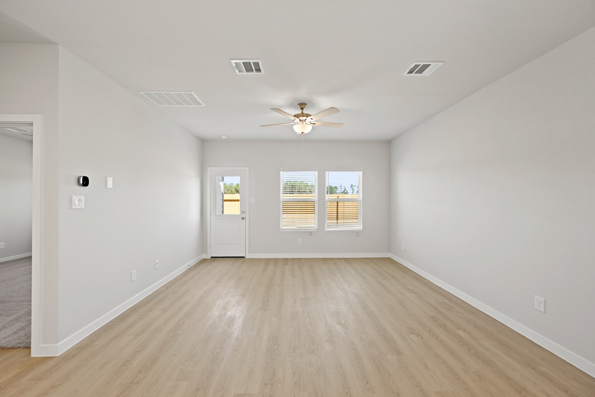 A room with a wood floor and a ceiling fan.
