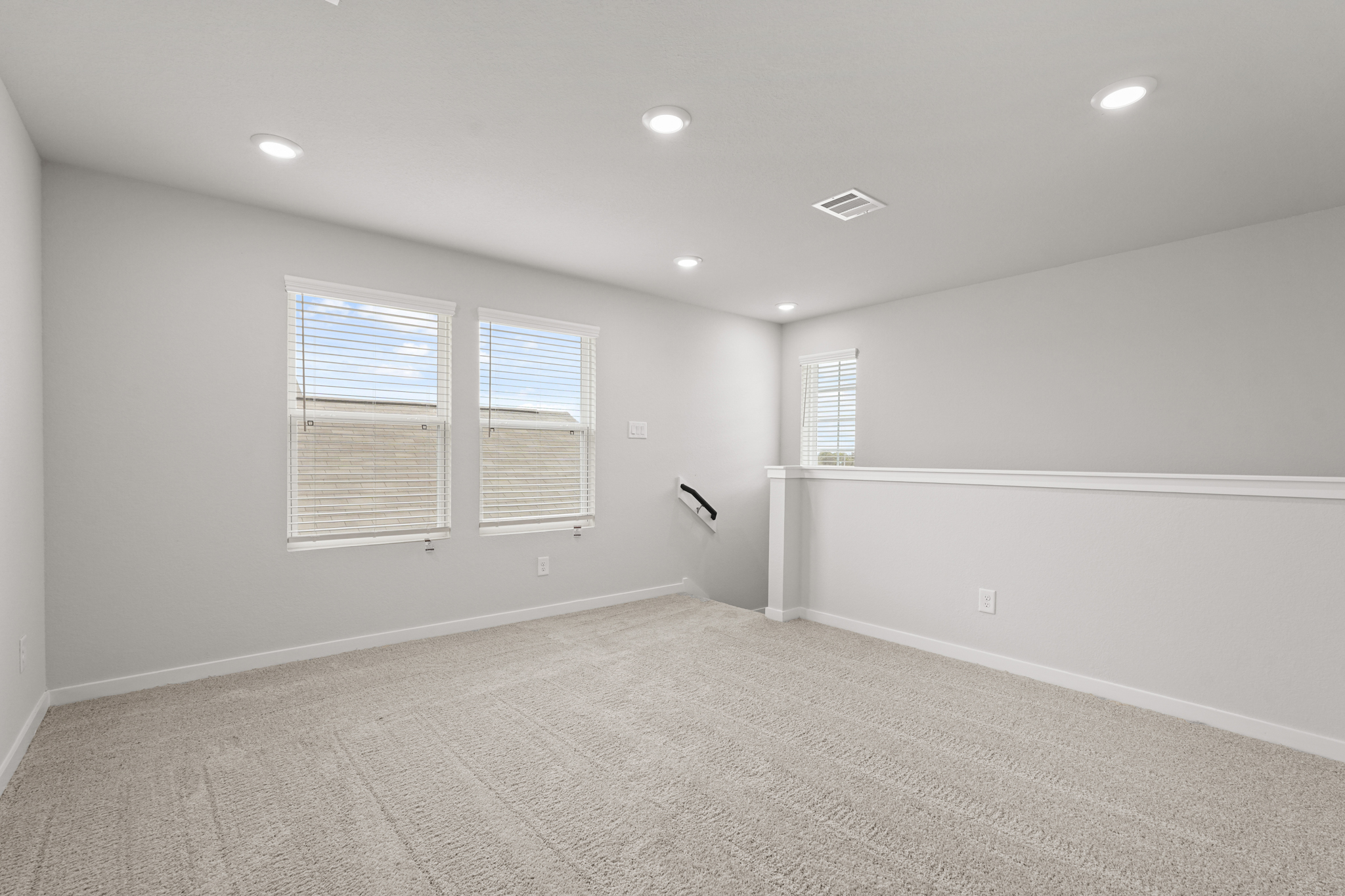 A room with a carpet and windows.