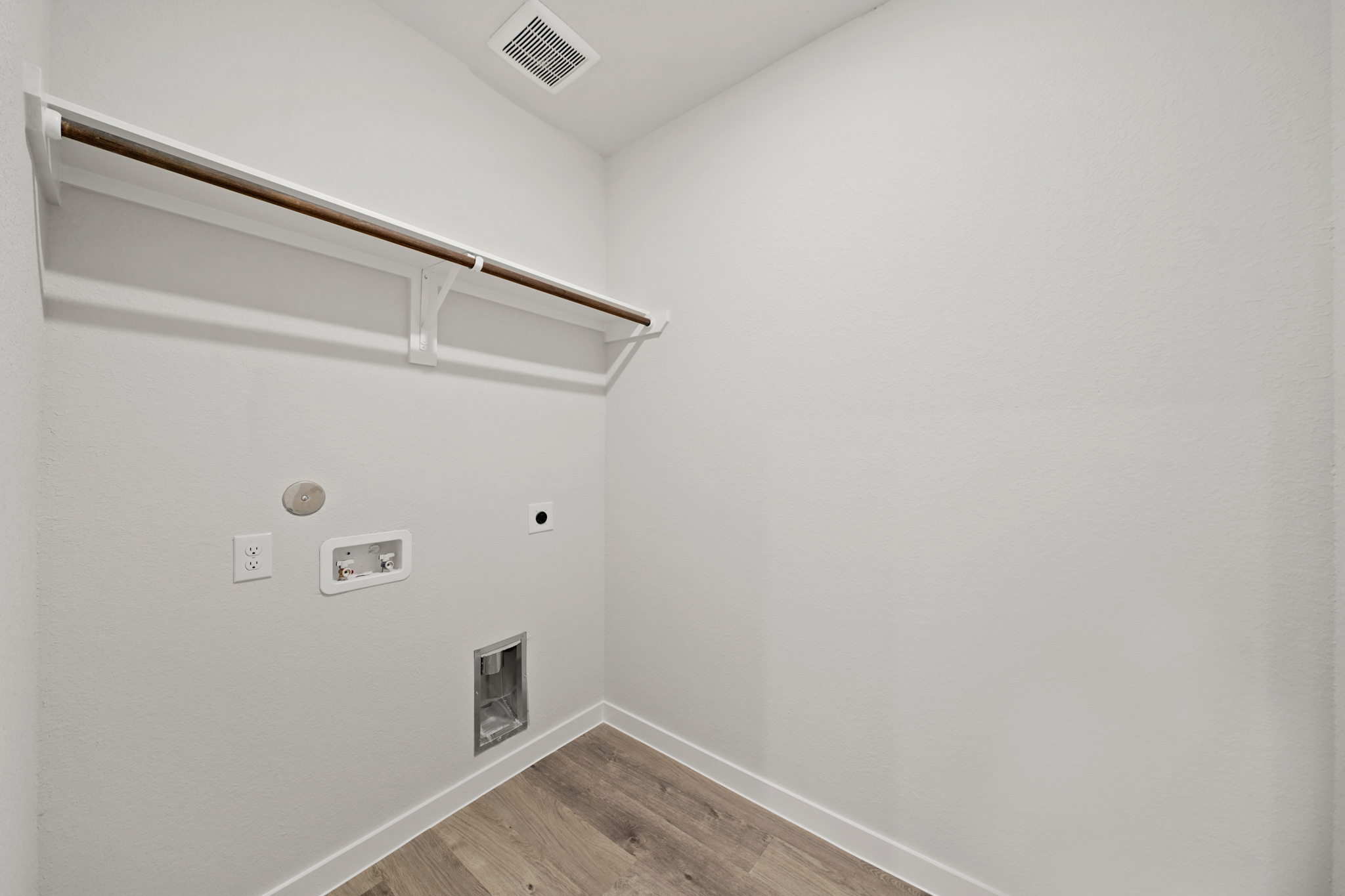 A white room with a wood floor and a wood floor.