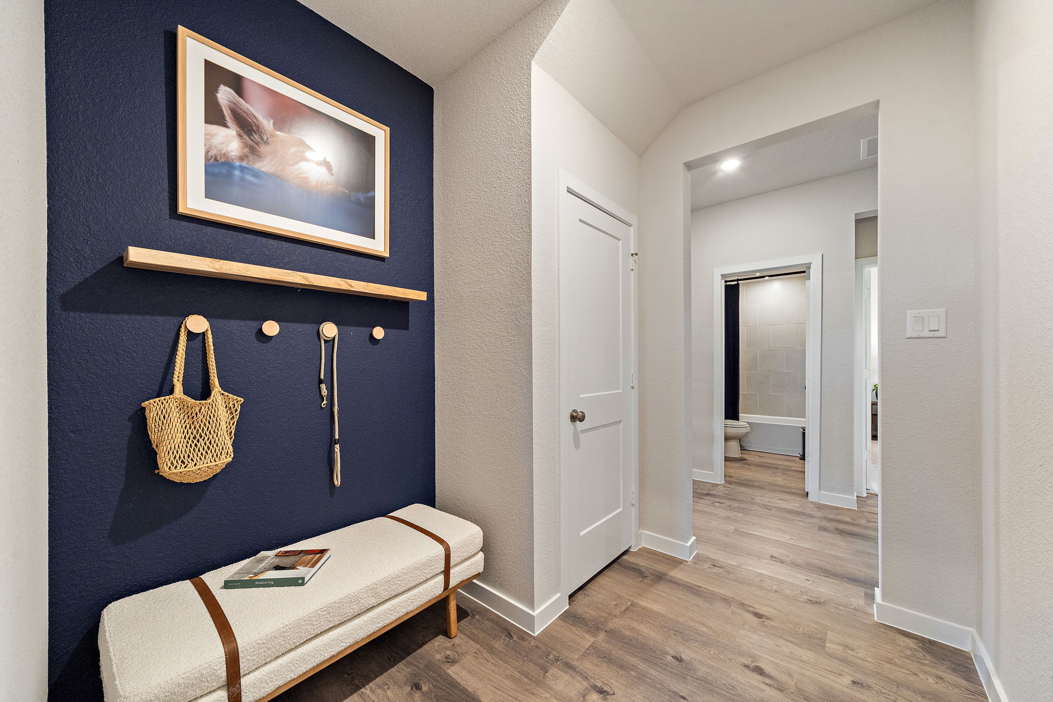 A room with a bed and a painting on the wall.