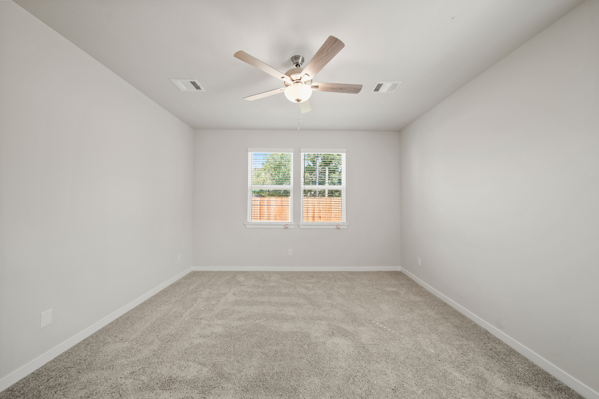 A room with a ceiling fan and a window.