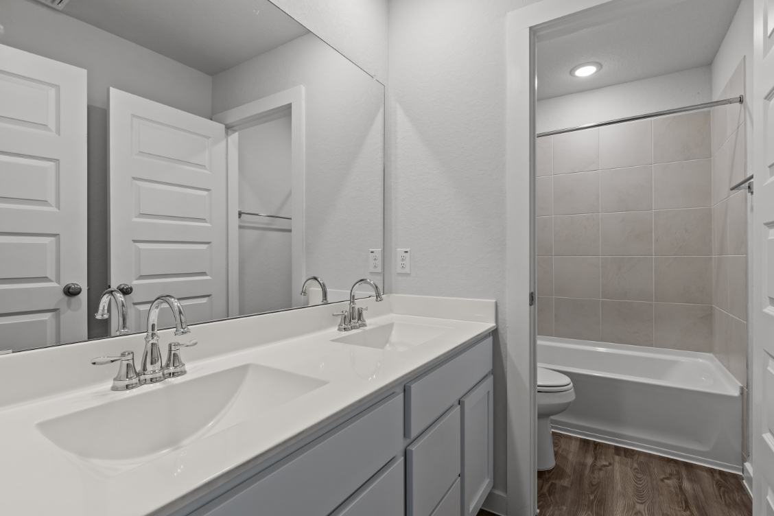 A bathroom with a tub sink and toilet.