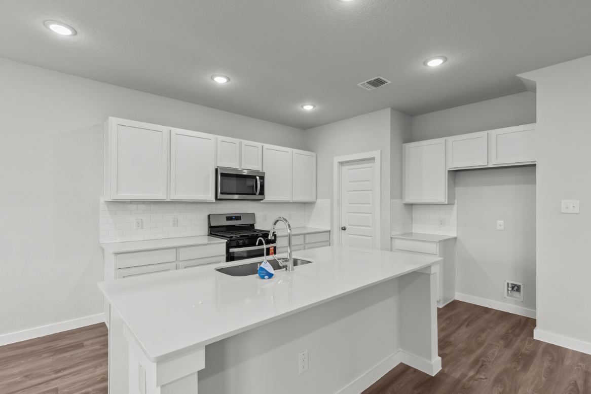 A kitchen with white cabinets.