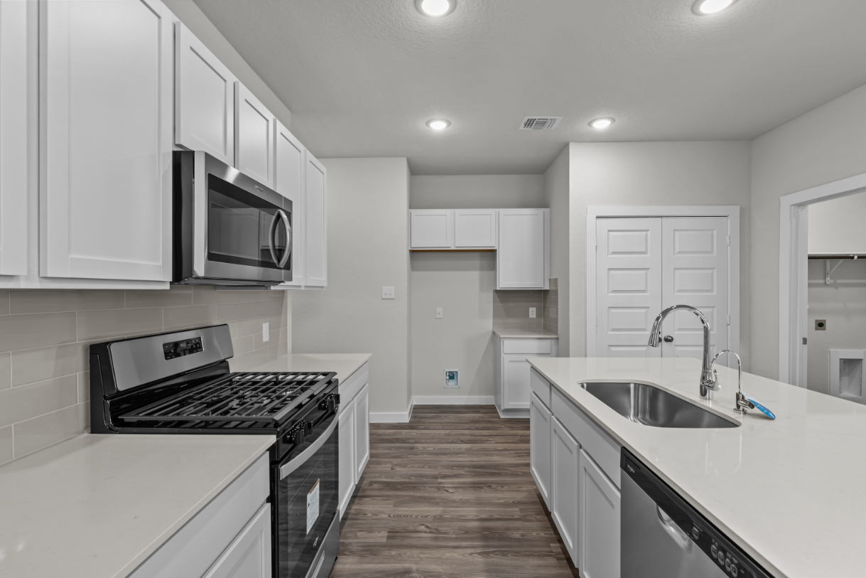 A kitchen with white cabinets.