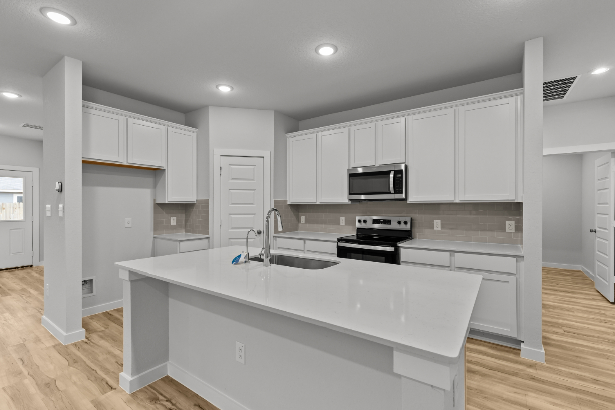 A kitchen with white cabinets.