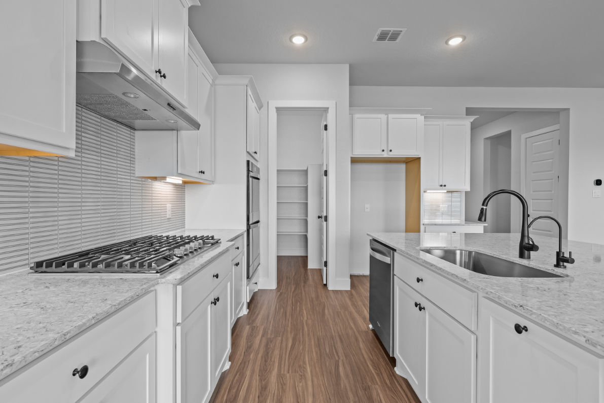 A kitchen with white cabinets.