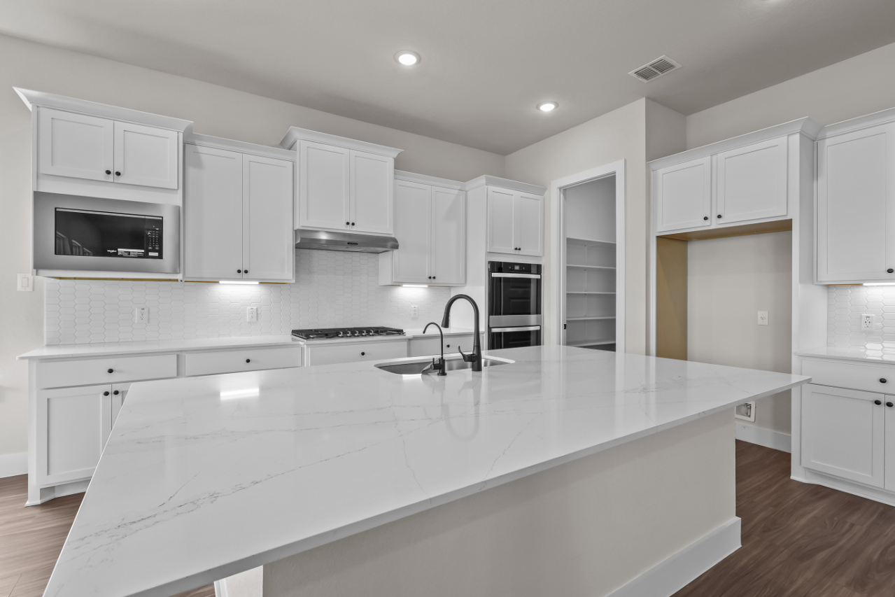 A kitchen with white cabinets.