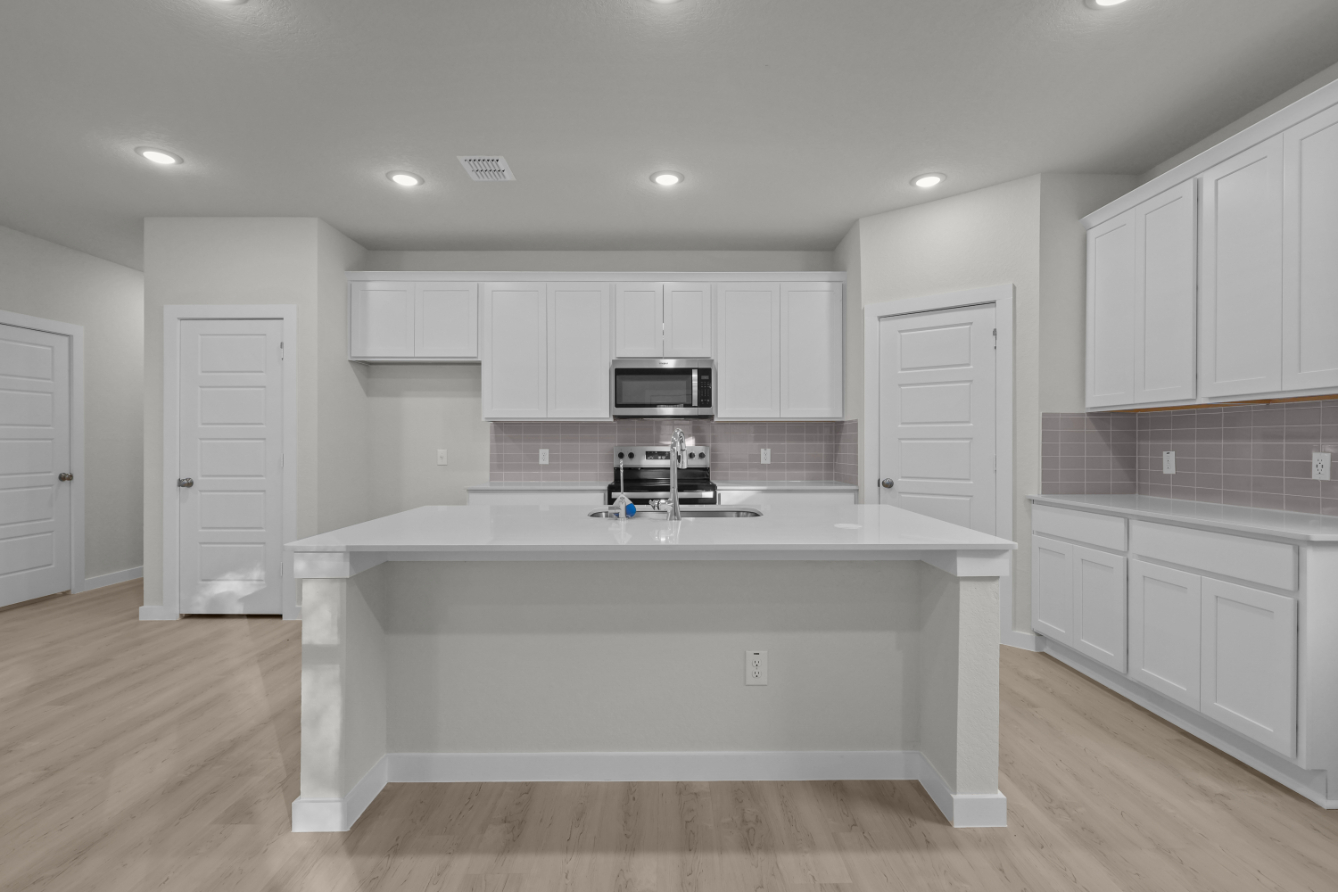 A kitchen with white cabinets.