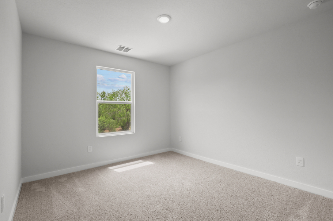 A room with a window and a carpet.