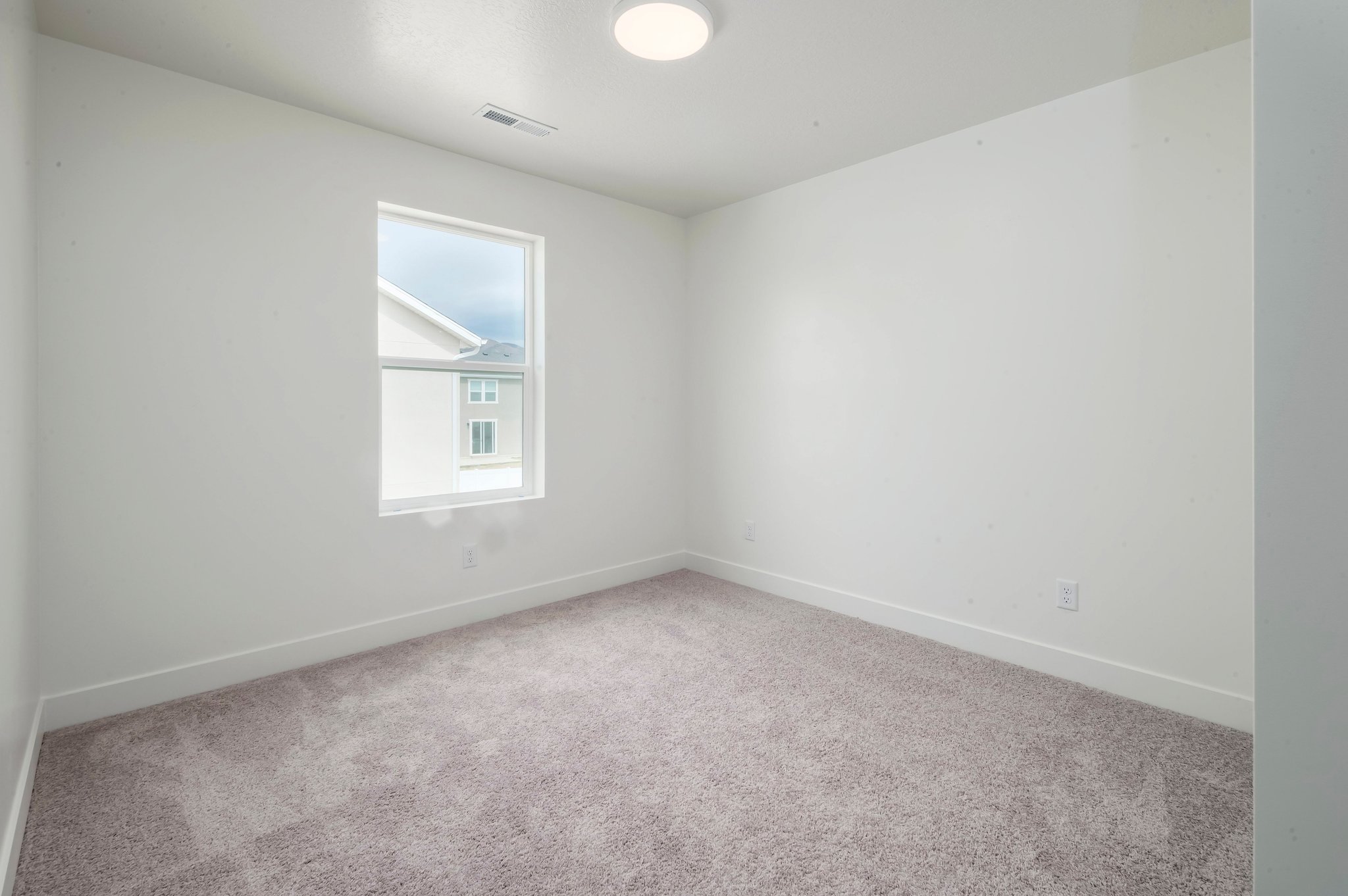 A room with a carpet and a window.