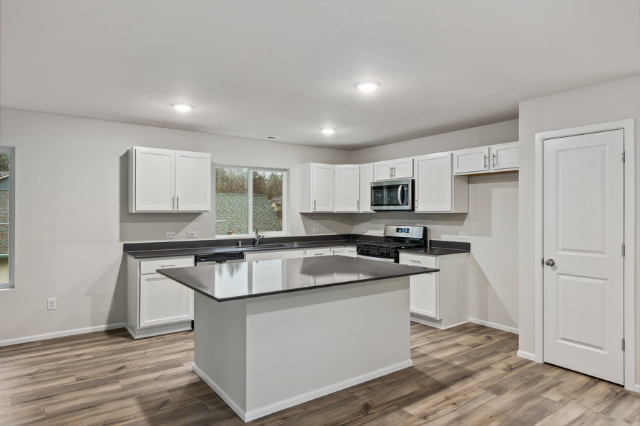 A kitchen with white cabinets.