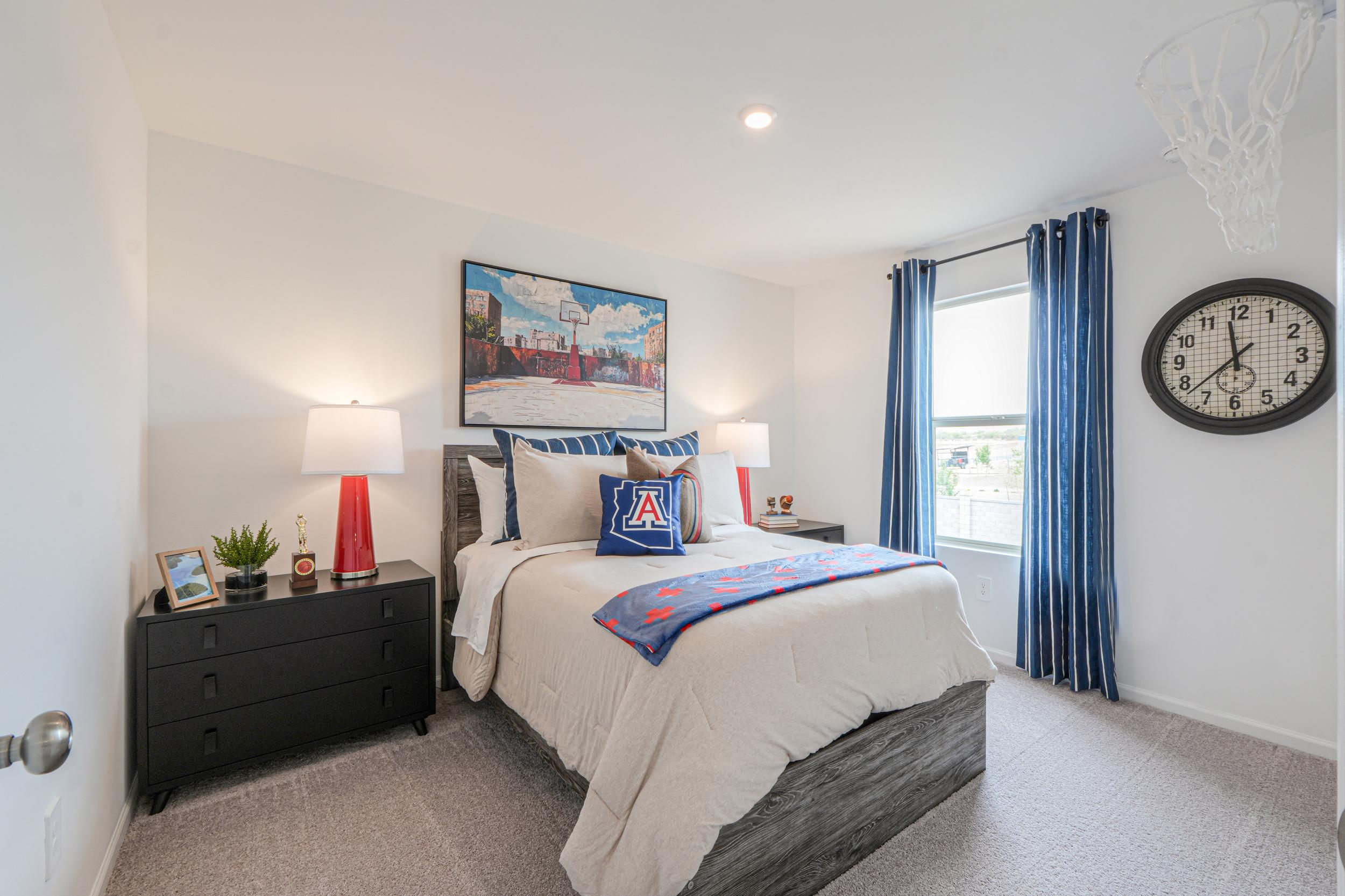 A bedroom with a bed and a clock on the wall.