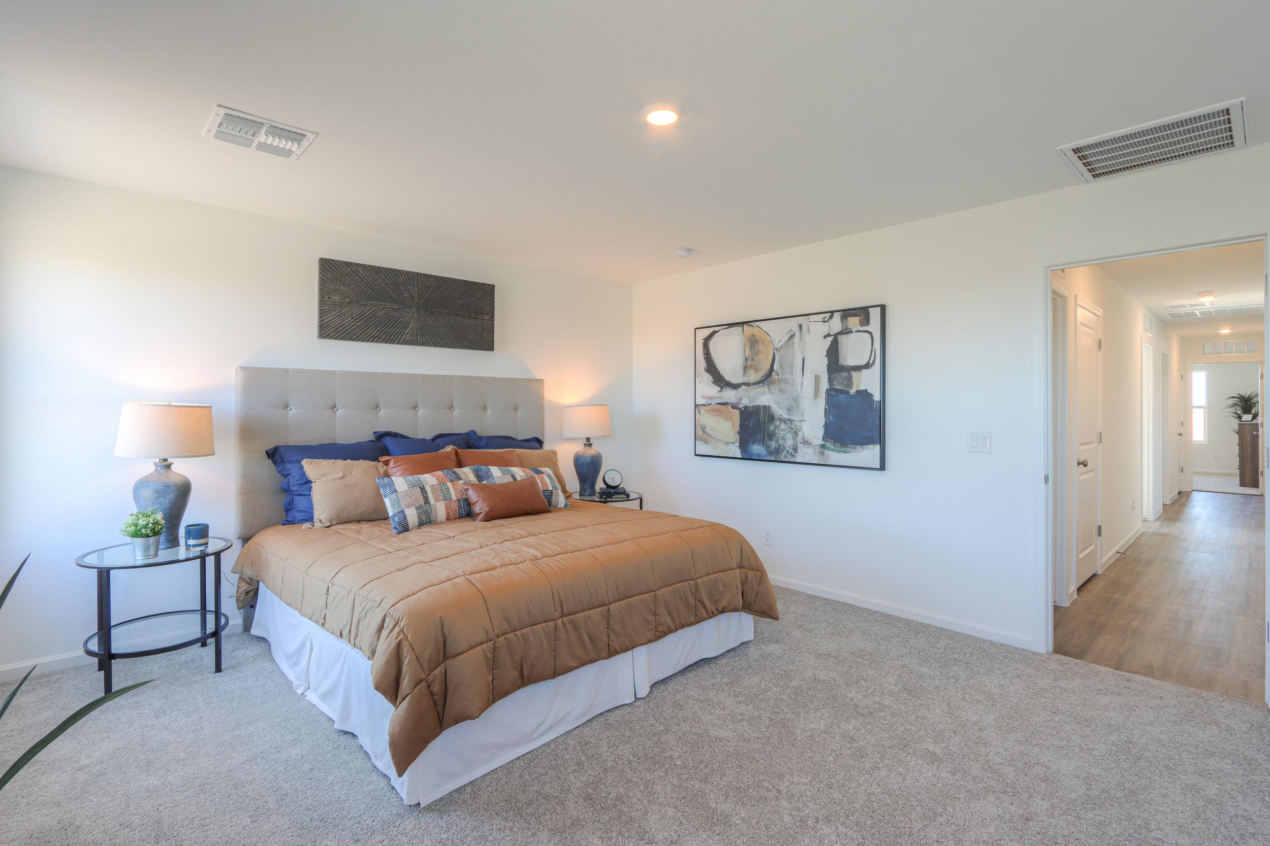 A bedroom with a bed and lamps.