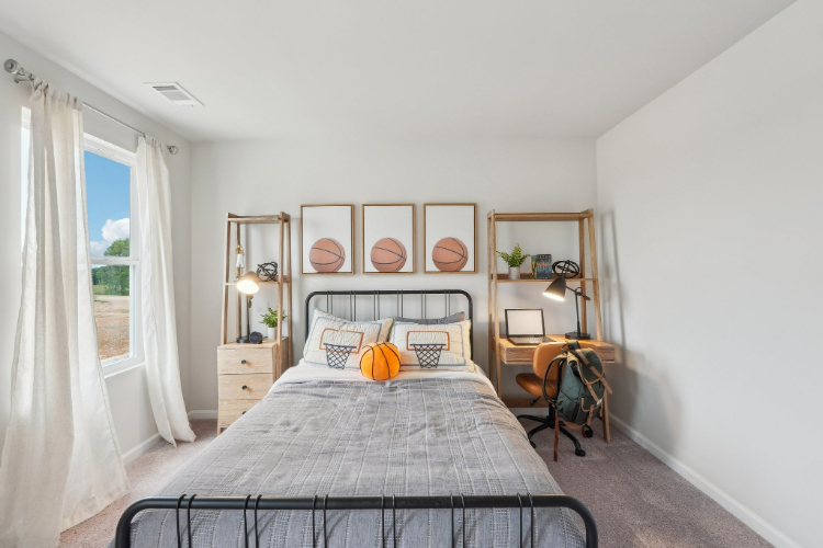 A bedroom with a bed and a desk.