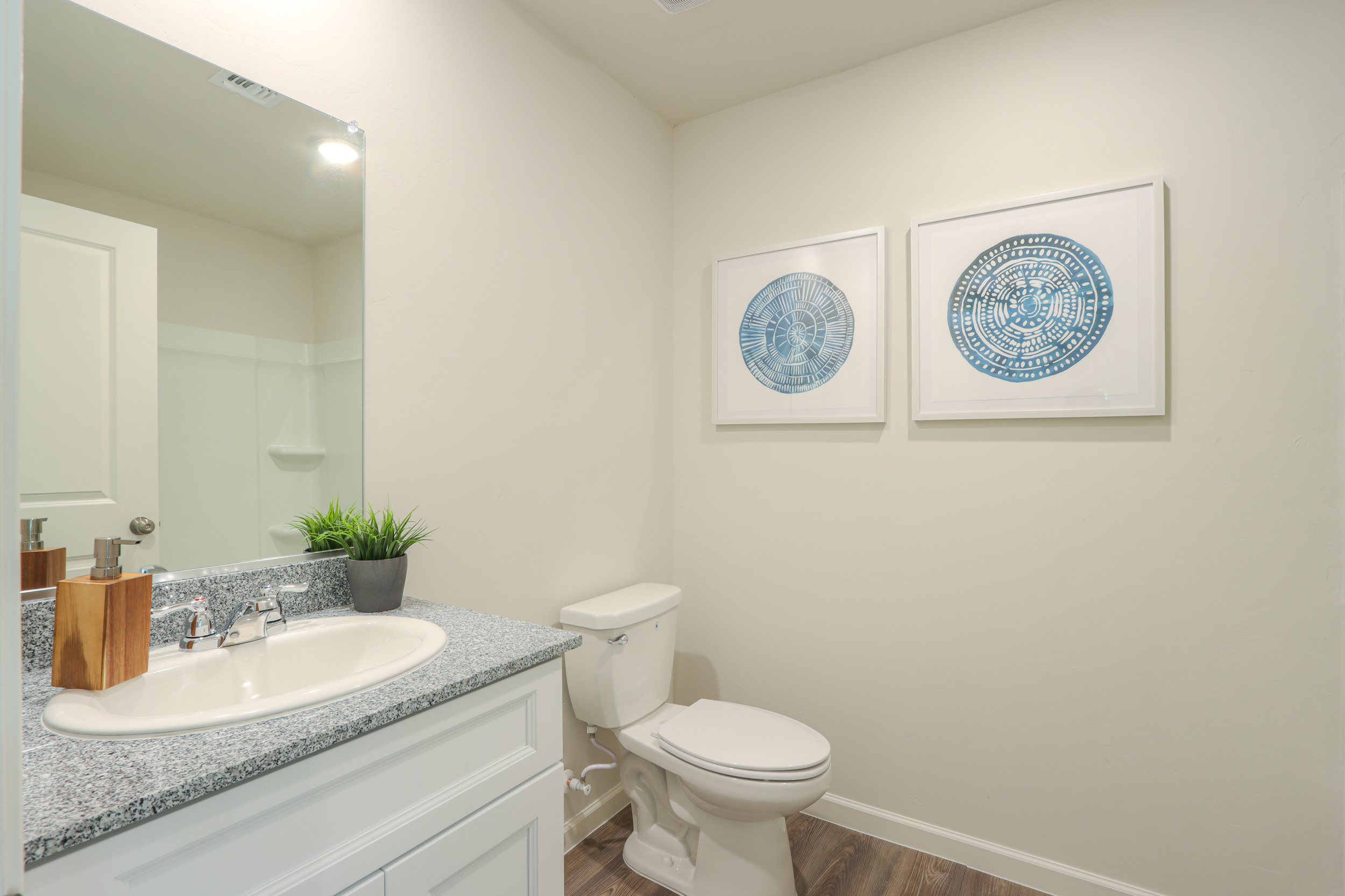 A bathroom with a sink toilet and a mirror.
