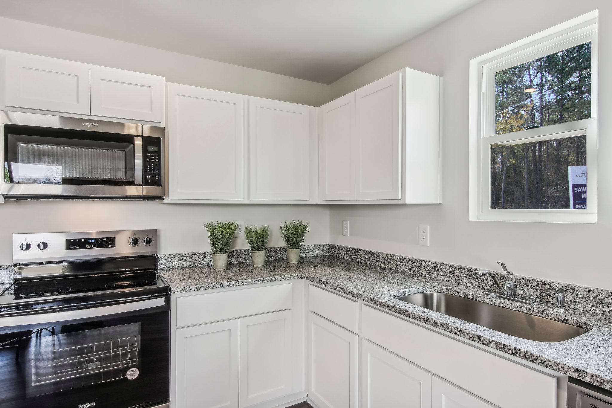 A kitchen with white cabinets.