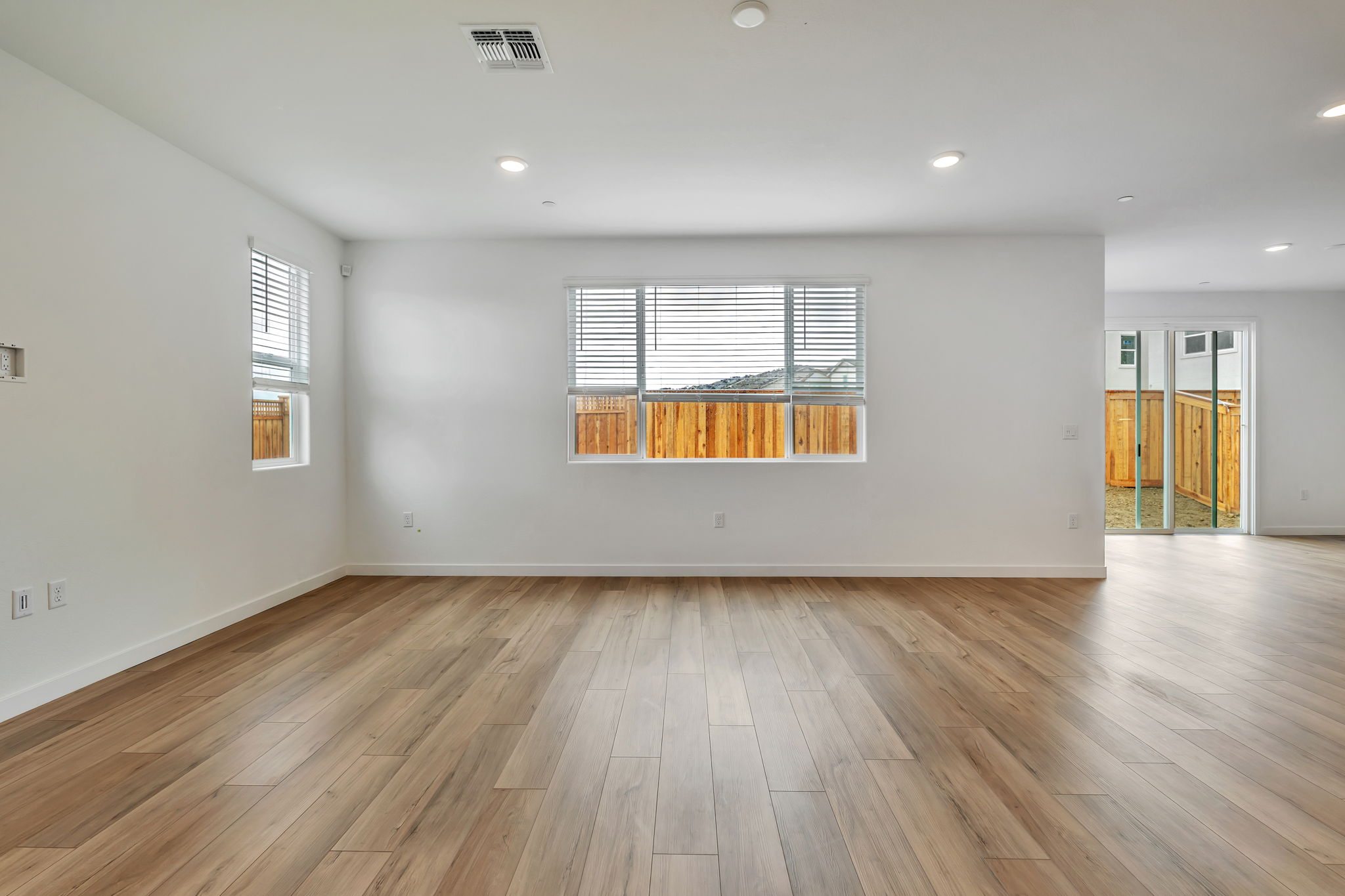 A room with a wood floor and a wood floor with a window.